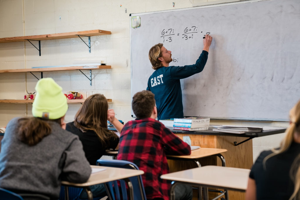 Teacher writing on the board at East